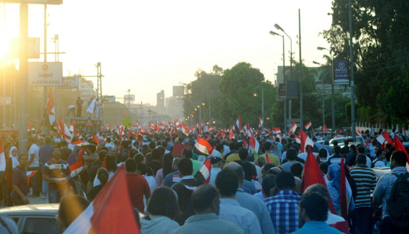 A protest march in Cairo, Egypt against the country’s first democratically elected president, Mohamed Morsi. The crowd is waving Egypt's flag.