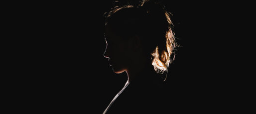 A woman's silhouette against a dark background.