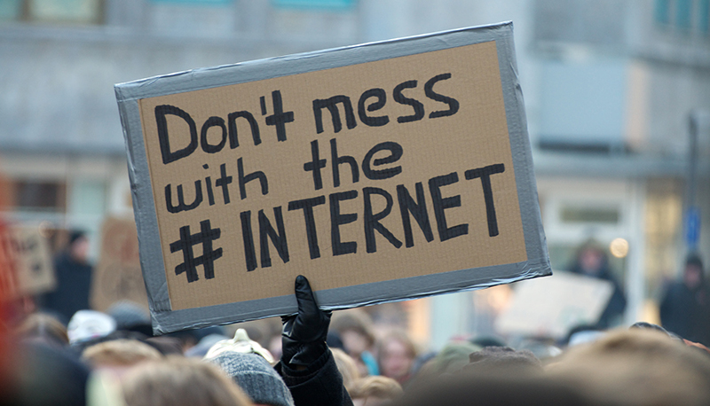 A protest sign reading "Don't mess with the #INTERNET."