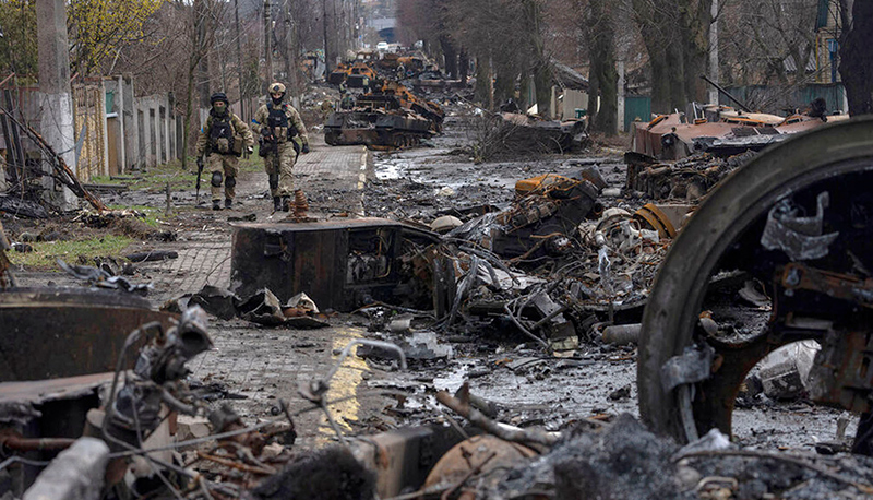 Soldiers walk amid destroyed Russian tanks in the outskirts of Kyiv, Ukraine.