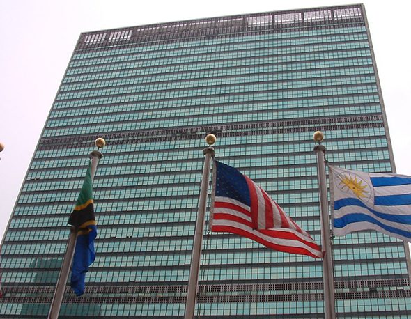 The American flag flies alongside the flags of other nations in front of the UN Headquarters in New York City