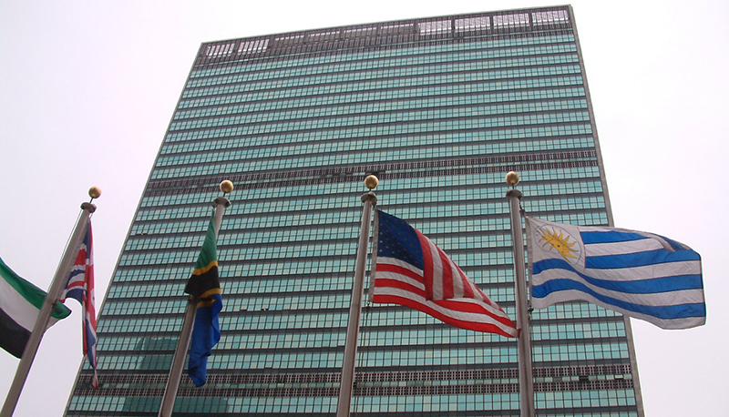 The American flag flies alongside the flags of other nations in front of the UN Headquarters in New York City