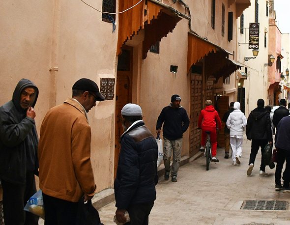 a group of people walking down a street in Meknes, Morocco