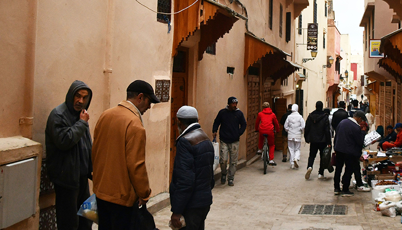 a group of people walking down a street in Meknes, Morocco