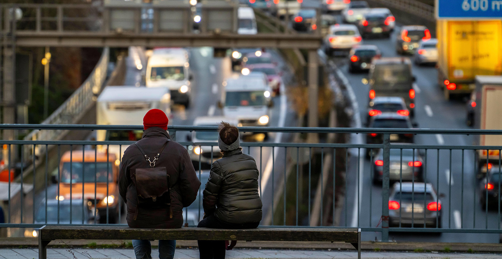 2 people sitting on a bench overlooking a traffic jam in Germany