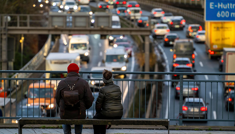 2 people sitting on a bench overlooking a traffic jam in Germany