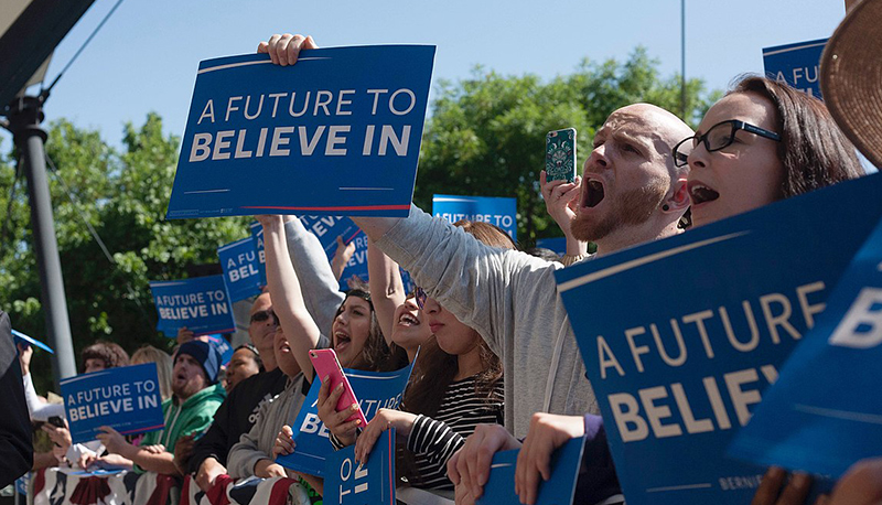 Young voters gather holding signs that read "A Future to Believe In" at a Bernie Sanders Rally in Stockton, CA, 2016.