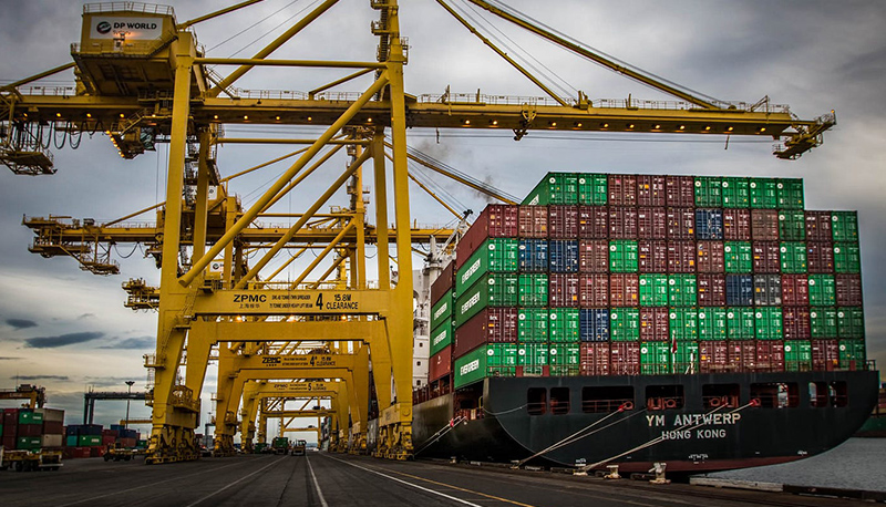 A Chinese container ship unloading stacks of shipping containers in port