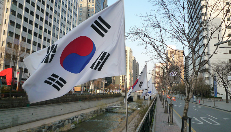 The South Korean flag, flying in the early light over the Cheonggye Stream.