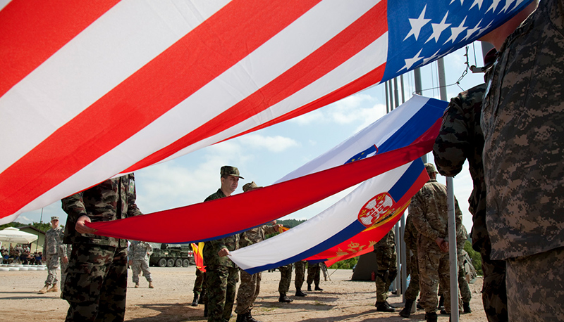 Soldiers from eight partnering NATO nations prepare to raise their flags