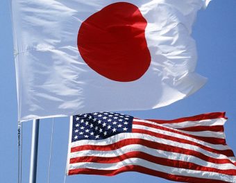 The Japanese and United States flags fly side by side over a military base