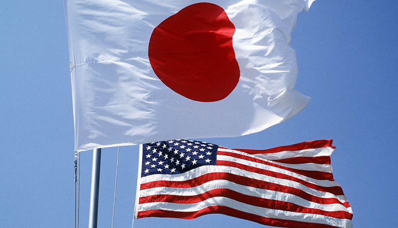 The Japanese and United States flags fly side by side over a military base