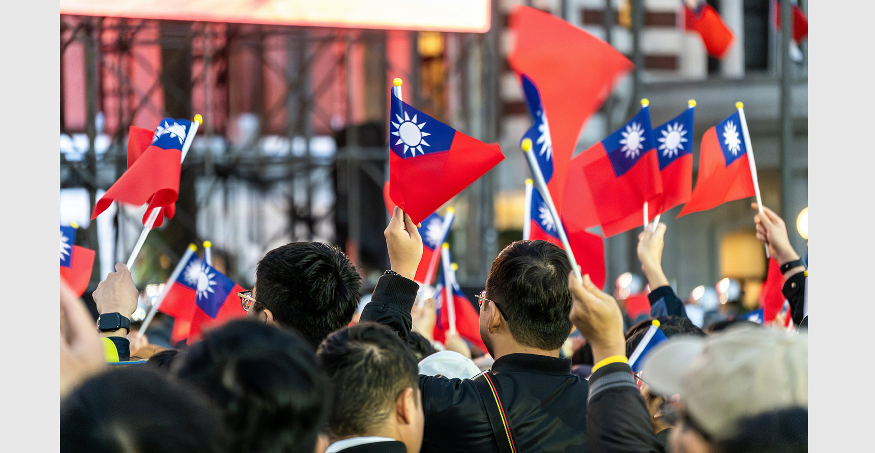 A group of people holding red and blue Taiwanese national flags