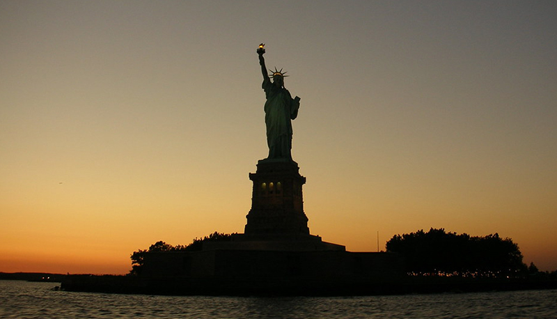 Silhouette photo of the Statue of Liberty taken at dusk