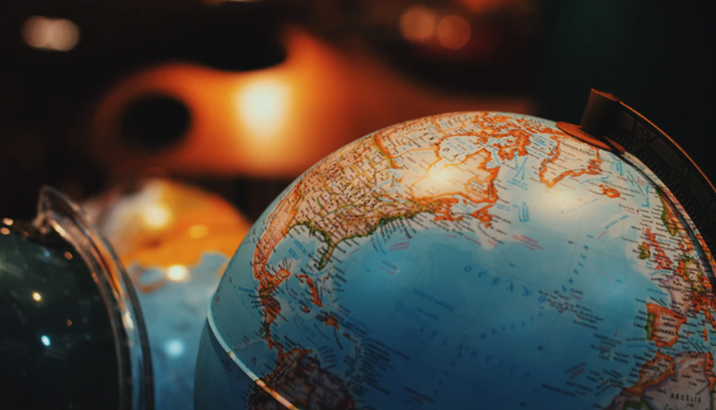 Selective focus photo of a desktop globe with soft light in the background