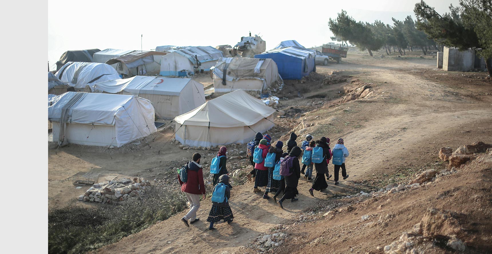 Photo of group of people walking through a dirt path.