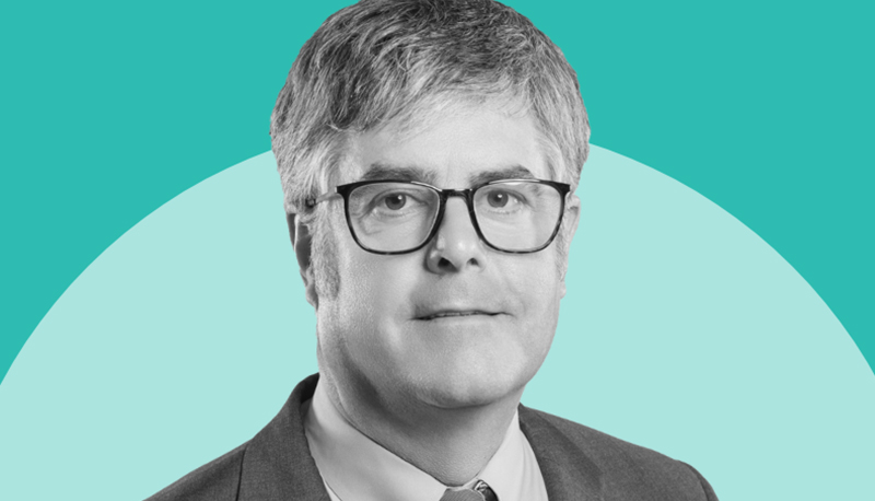 A black and white headshot photo of Thom Mason overlaid on a two-tone teal background
