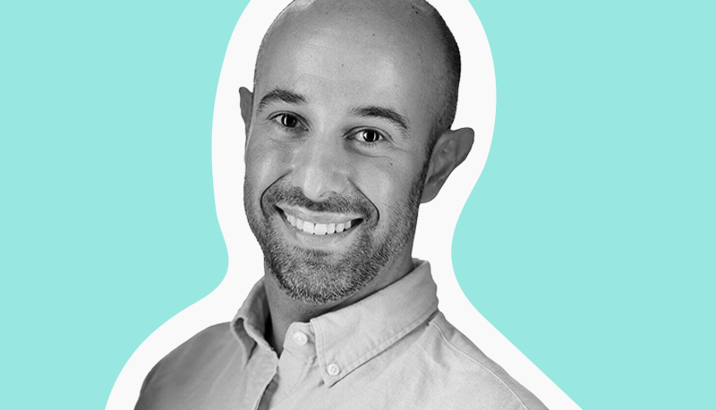 Black and white headshot of Cameran Ashraf on a teal background