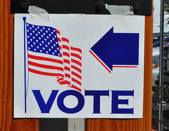 A paper sign taped to the wall directing voters to a polling place in the United States