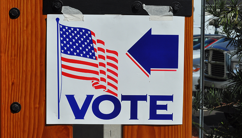 A paper sign taped to the wall directing voters to a polling place in the United States